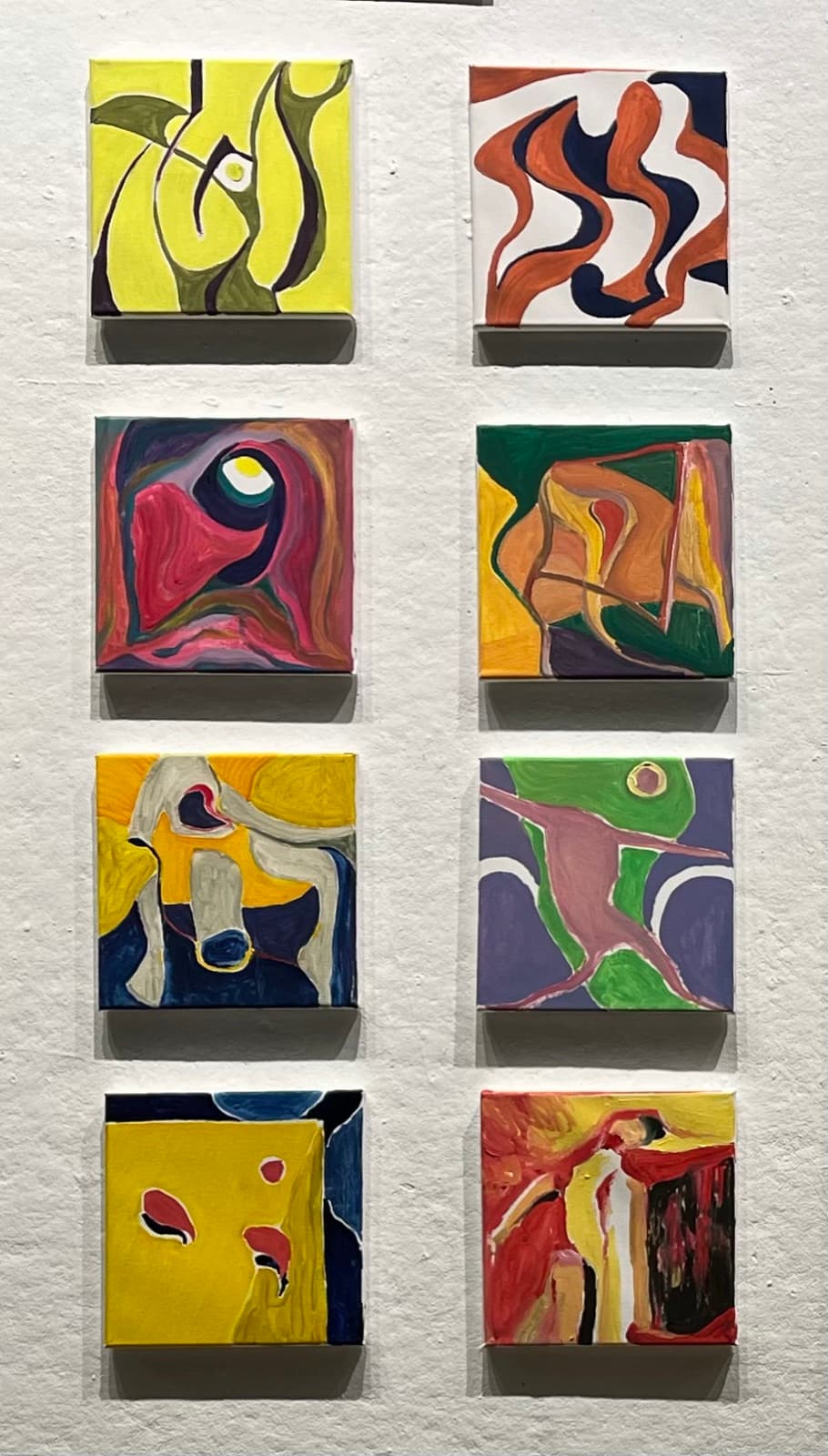 Problem Solving — eight small abstract oil canvases hung in a two-column grid on a white wall, each a different color study of tangled, searching forms.