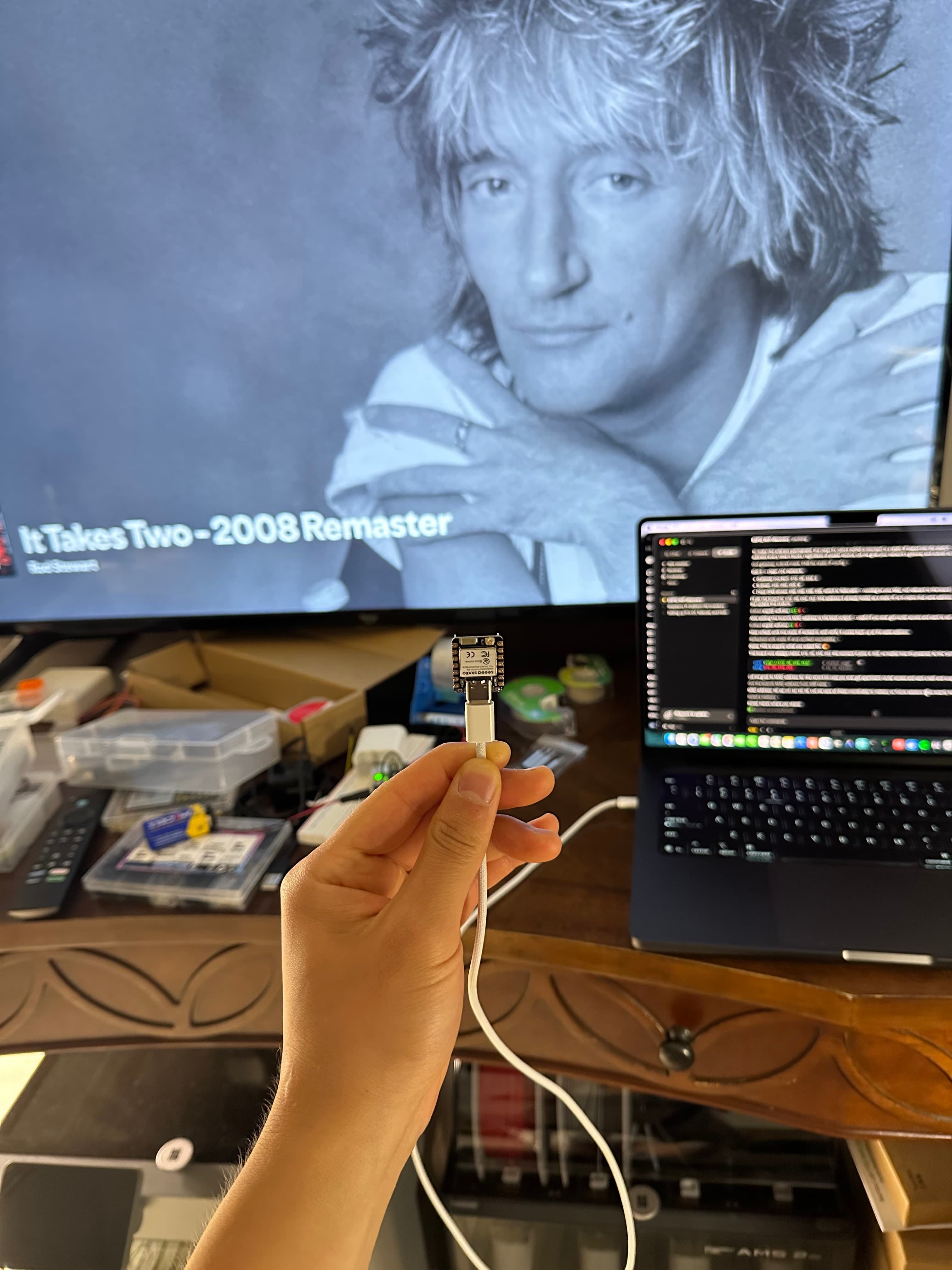 Flashing firmware — laptop in the terminal, a XIAO on a USB tether.
