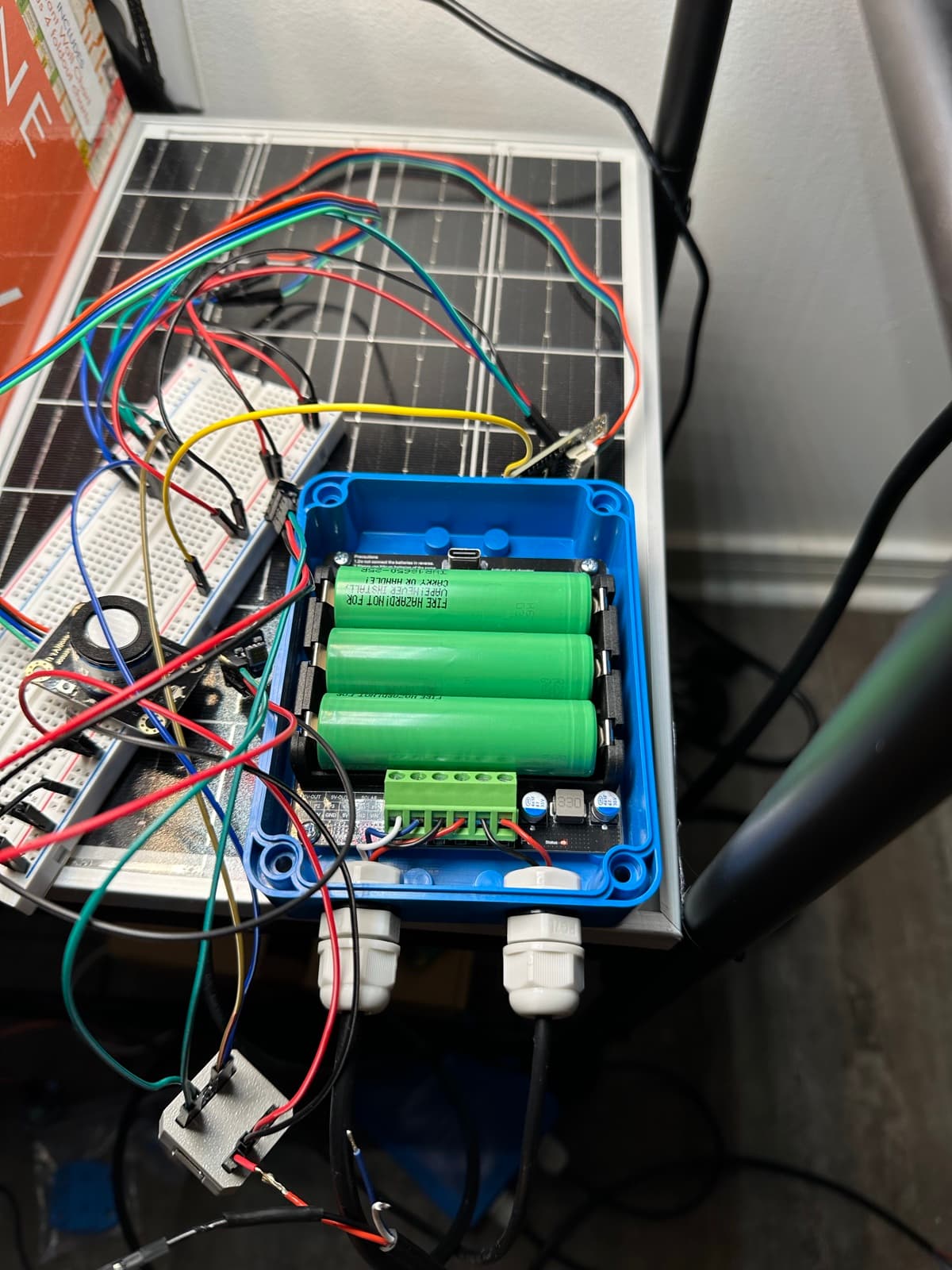 Inside the node: three 18650s on the terminal block, mid-rewire.